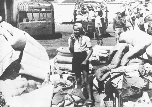 Een Nederlands meisje omringd door bagage van Nederlandse geïnterneerden, die worden geëvacueerd uit kamp Banyubiri 